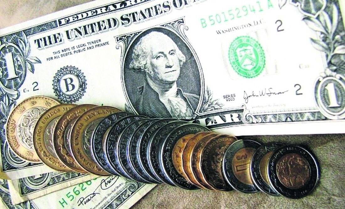 Monedas mexicanas sobre un billete de un dolar